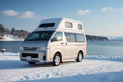 冬の雪景色の中に停車したキャンピングカー|湖畔での車中泊旅の様子